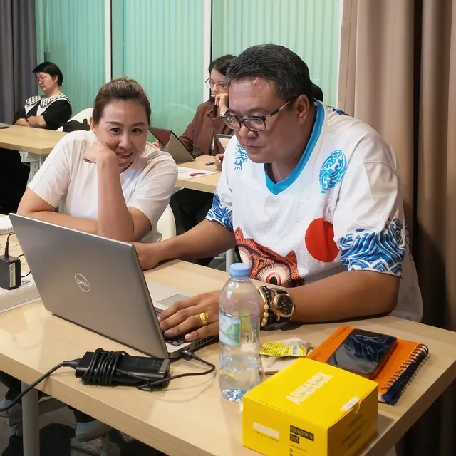 ผู้เรียนยิ้มระหว่างลงมือทำบนโน้ตบุ๊ก